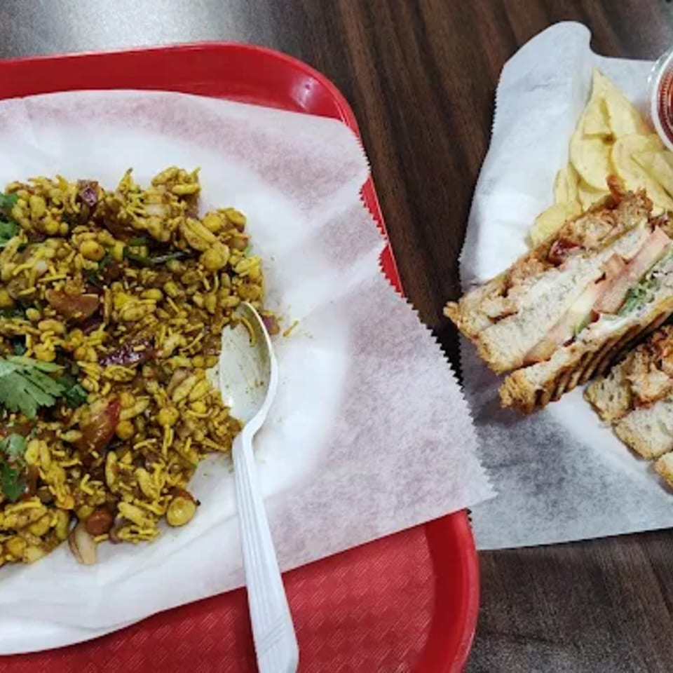 Chai Wyy's Indian snack, a savory mixture of puffed rice and spices, next to a grilled sandwich.